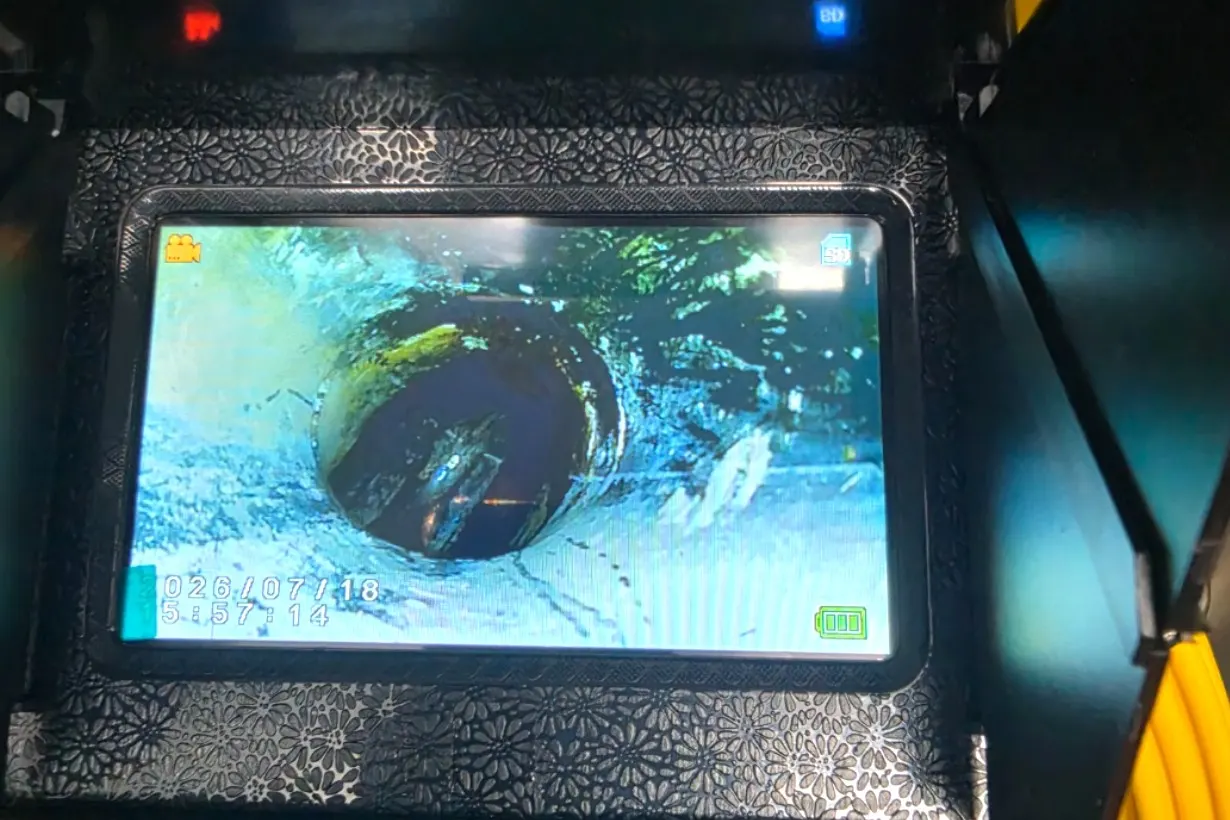 The monitor in the back of the van during a CCTV drain survey, showing the inside of a clay pipe.