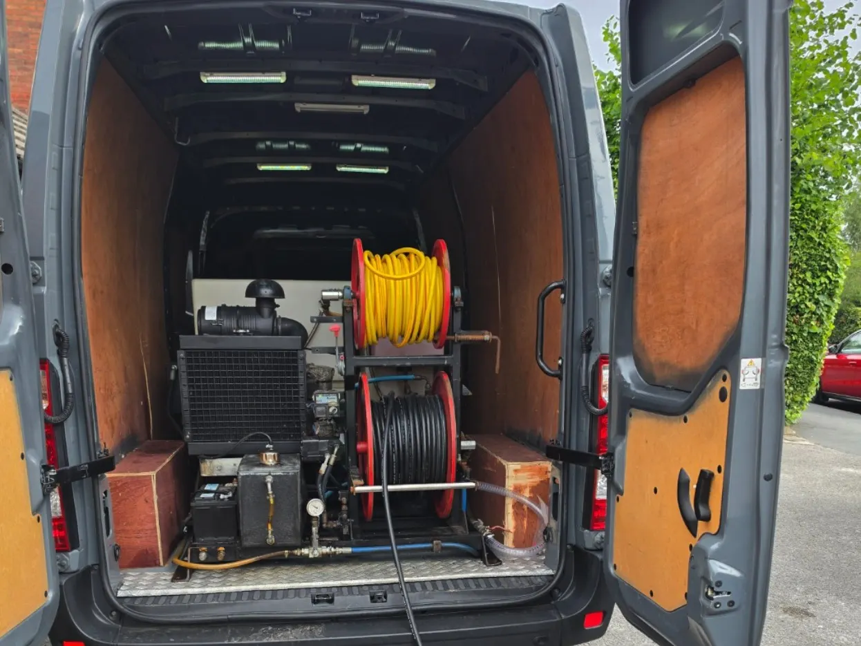 The back of the van open on the high pressure jetting unit, its pump and its two hose reels.